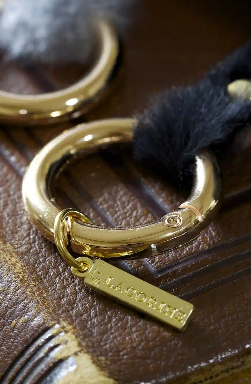 Lacorine alpaca fur pom pom keyring accessory with soft, fluffy beige pom pom and metal keyring attachment.
