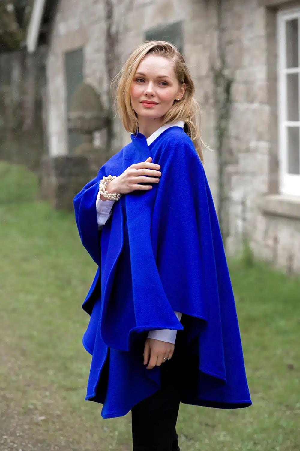 Lacorine classic alpaca wool cape in cobalt blue, showcasing its cozy, elegant design and textured fabric detail.