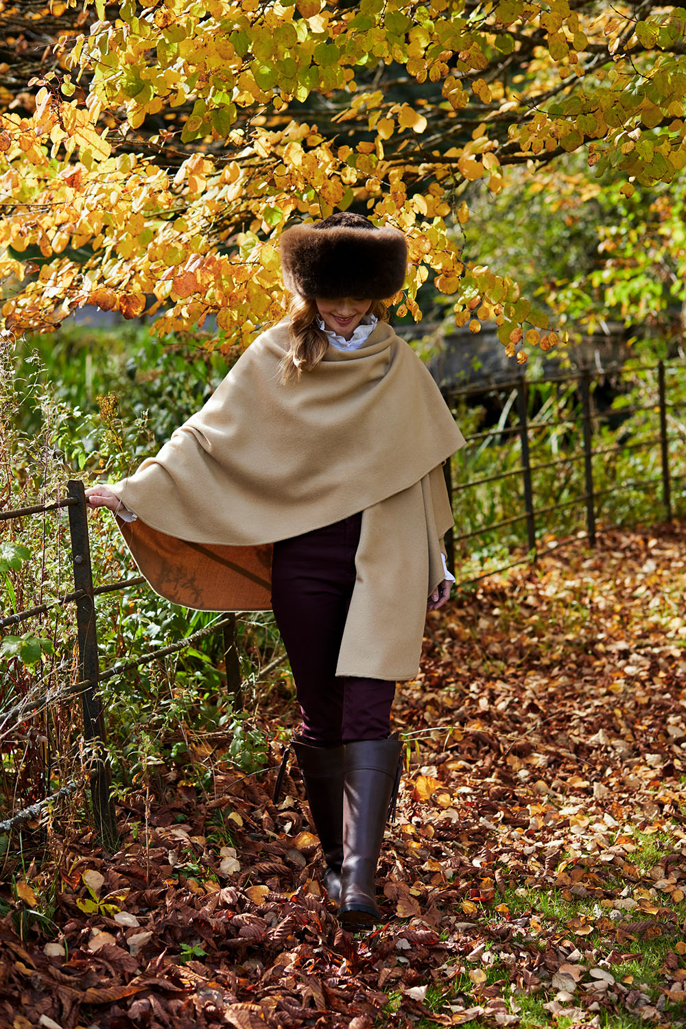 Lacorine classic alpaca wool cape in light camel color draped on a hanger, showcasing its cozy, elegant design.