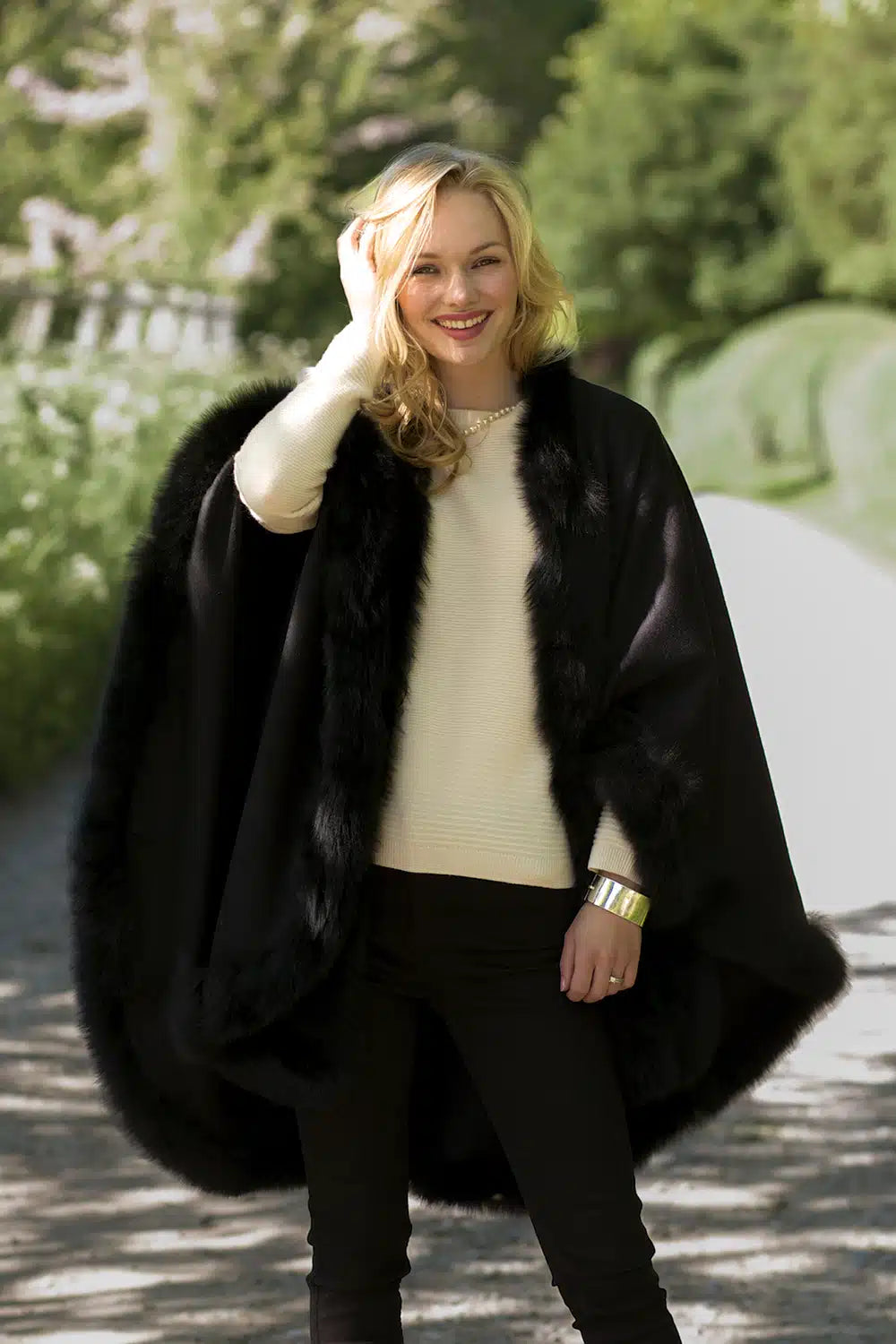 Black Annabelle fur-trimmed alpaca cape by Lacorine, showcasing its luxurious wool fabric and elegant fur details.