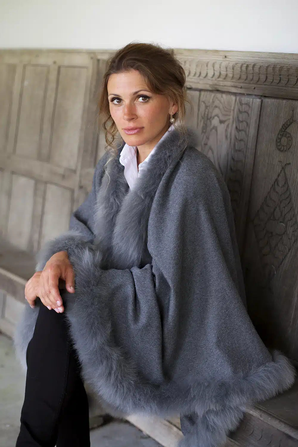 Grey Annabelle fur-trimmed alpaca cape by Lacorine, shown draped on a mannequin with luxurious fur trim detail.