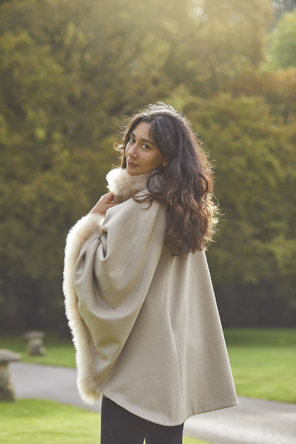 Beige fur-trimmed alpaca coat by Lacorine, showing the back view with plush fur details and elegant cape design.