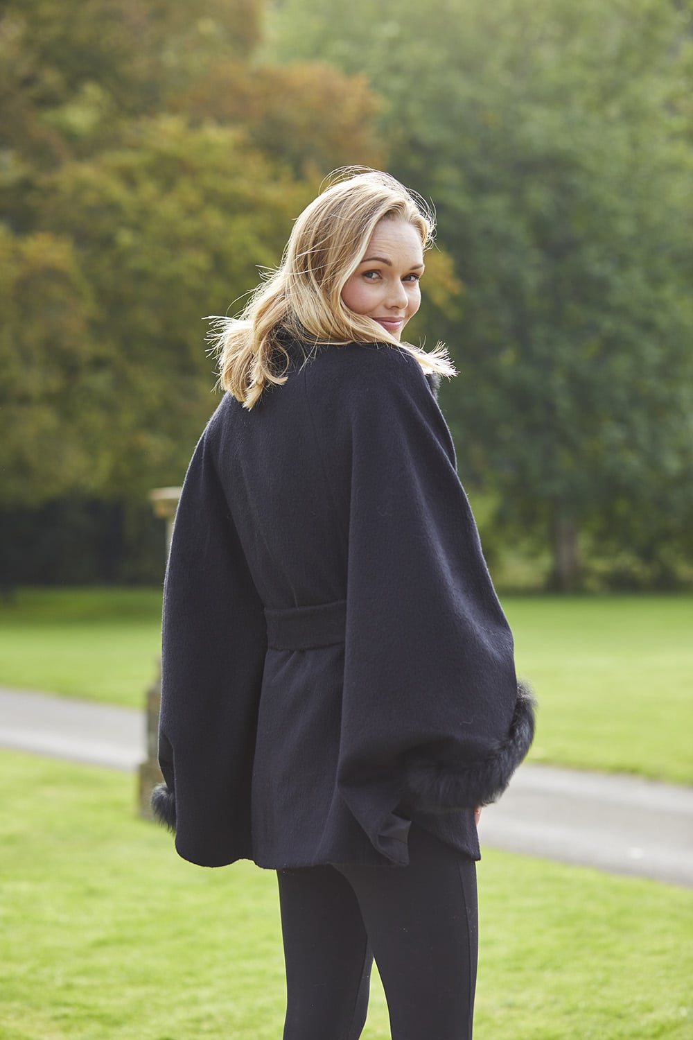Black Lucia fur-trimmed alpaca cape coat by Lacorine, featuring plush fur accents and cozy alpaca fabric.