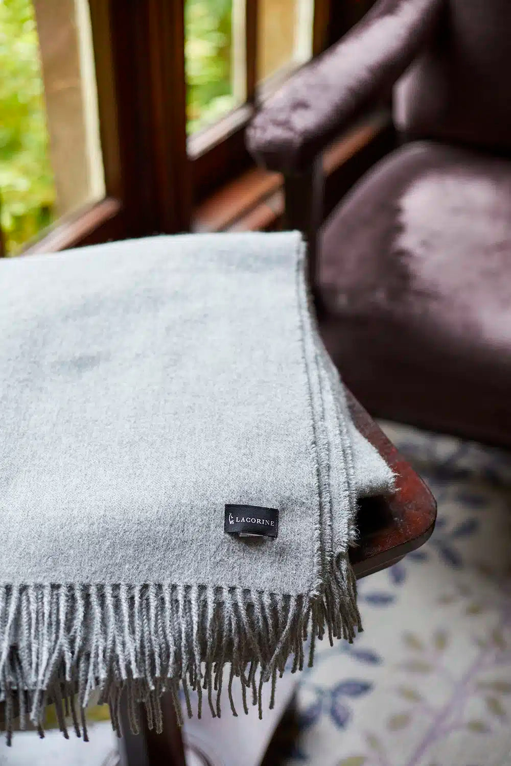 Grey luxury alpaca throw blanket from Lacorine, made in Peru, soft and cozy homeware accessory.