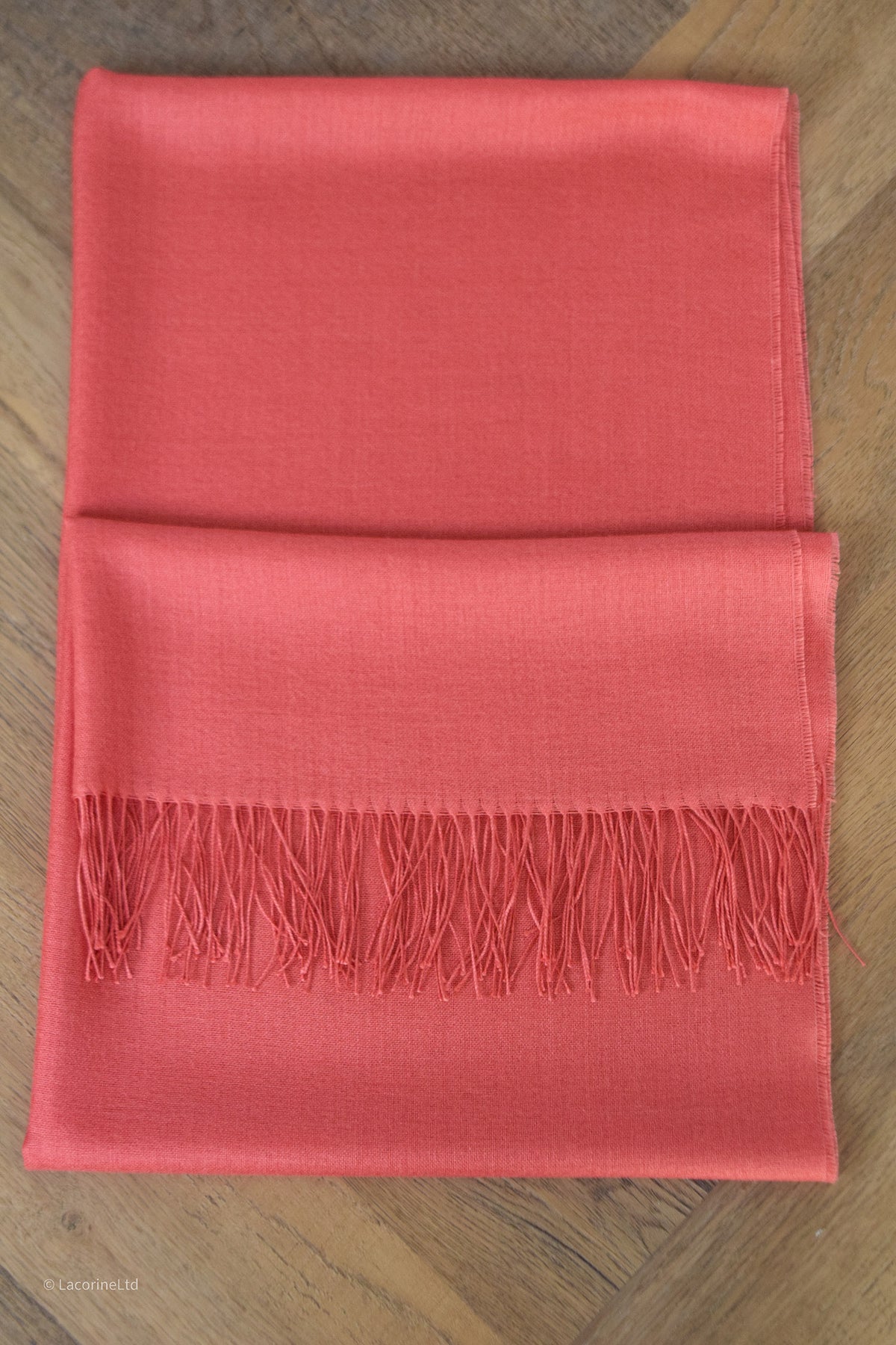Salmon-colored Lacorine Signature Pashmina knitwear displayed flat with soft, luxurious fabric and detailed knit pattern.