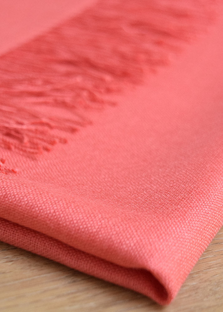 Salmon-colored Lacorine Signature Pashmina knitwear draped elegantly, showcasing soft, luxurious fabric and fine craftsmanship.