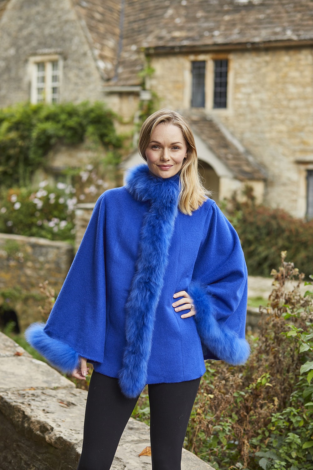 Women's cobalt blue alpaca poncho with luxurious fur trim, designed for warmth and style by Lacorine.