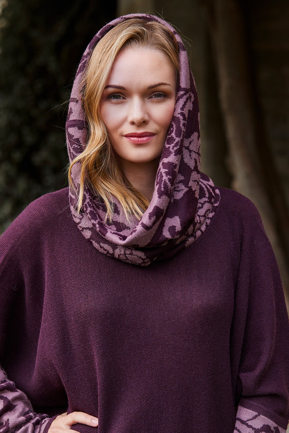 Lacorine Primavera alpaca poncho in dusty lilac and aubergine with a cozy, knit texture and fringed edges.