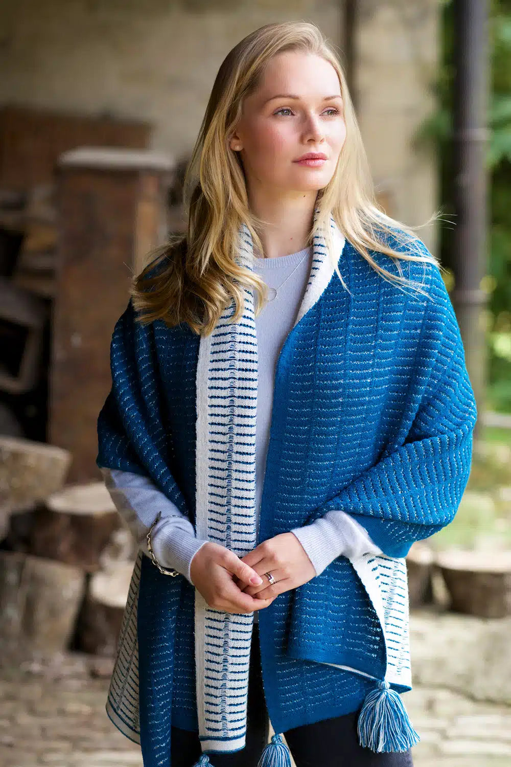 Lacorine Natalia oversized alpaca scarf in turquoise and white, soft and warm, draped showing its plush fabric and stylish design.