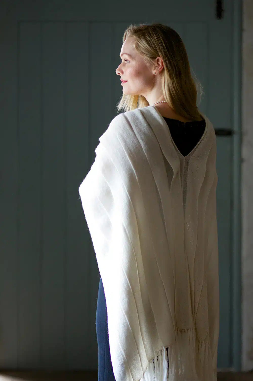 Cream luxury wool shawl by Lacorine, showcasing soft fabric and elegant drape in a close-up view.
