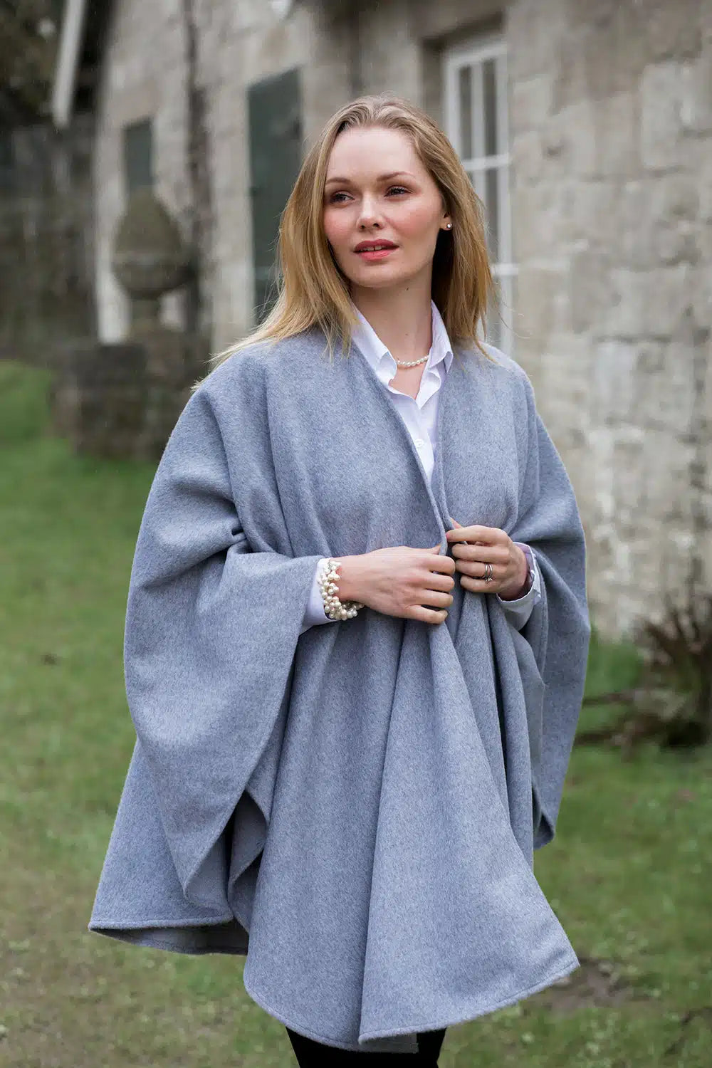 Lacorine classic alpaca wool cape in silver grey draped over a mannequin showcasing its soft, cozy texture and stylish design.