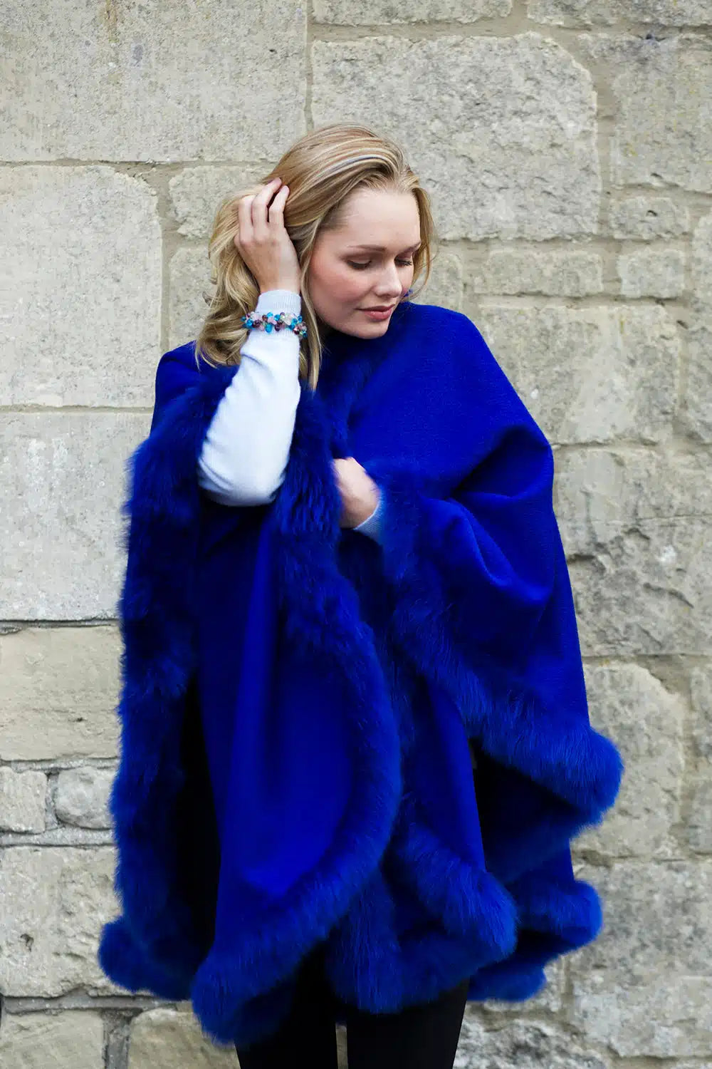 Cobalt blue Alpaca cape with fur trim from Lacorine, featuring a cozy and elegant design ideal for cold weather.
