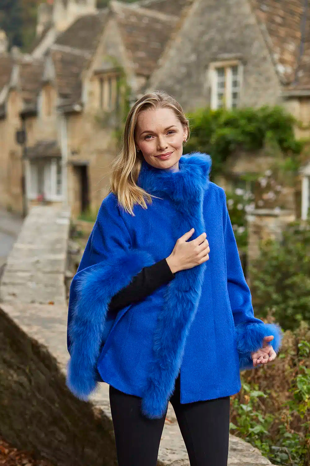 Cobalt blue Lacorine Felicity alpaca poncho with fur trim, showcasing soft wool and stylish cozy design.