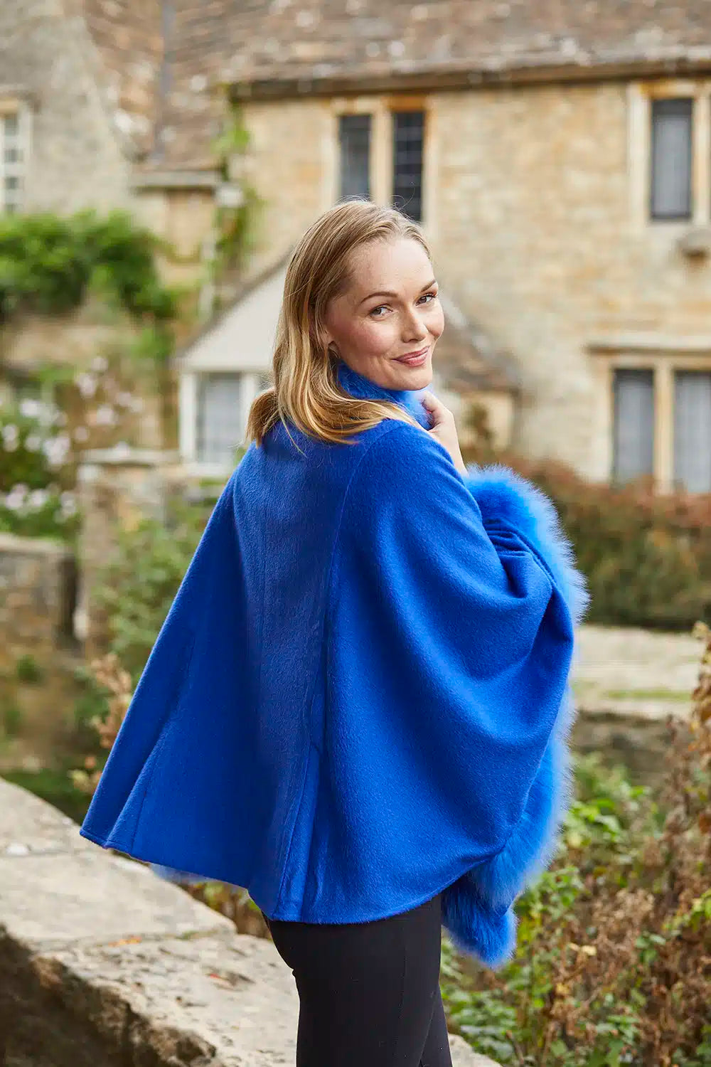 Cobalt blue alpaca poncho with fur trim from Lacorine, featuring a cozy and stylish design.