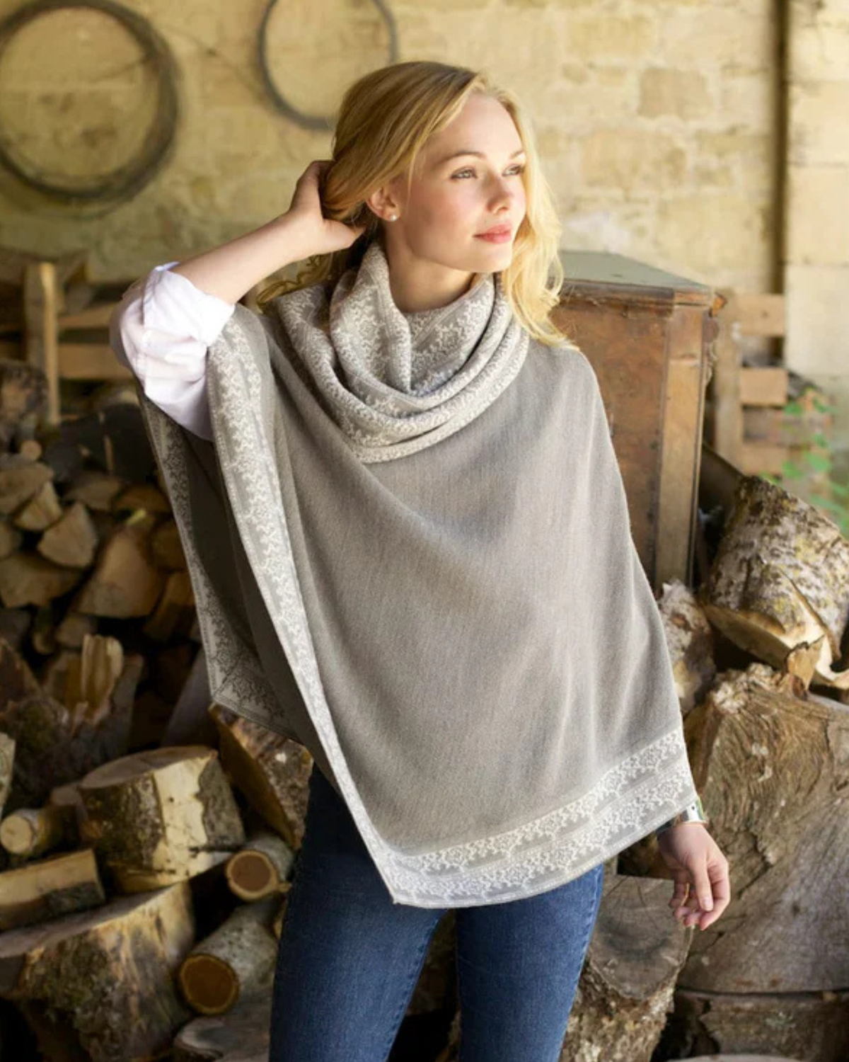 Lacorine Valentina alpaca poncho in soft, luxurious beige with intricate knit pattern and fringed edges.