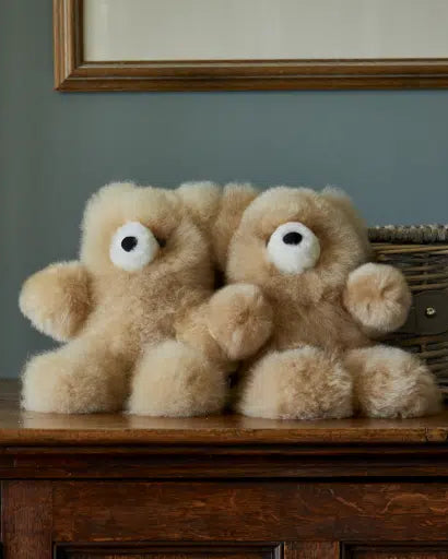 Two Classic Charles alpaca fur teddy bears in Champagne sitting together on a wooden dresser #Colour_Champagne